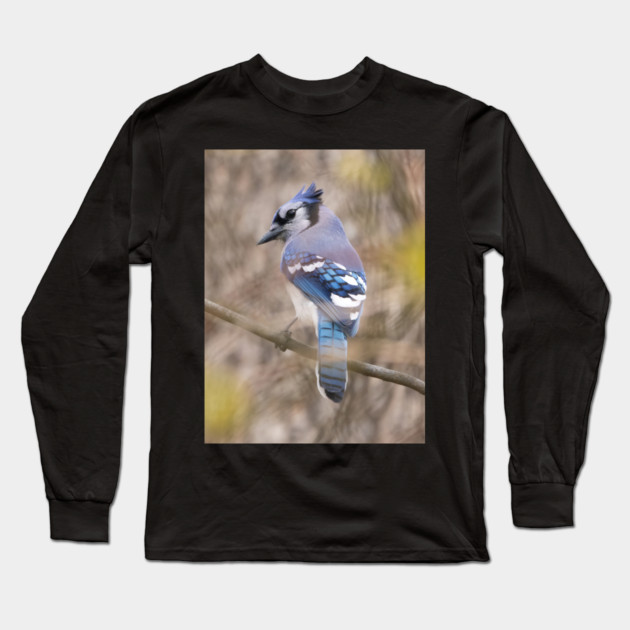 Blue Jay with brown and grey blurred background and green blurred leaves Long Sleeve T-Shirt by BirdsnStuff