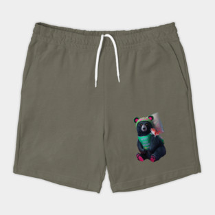 black bear wearing a green bib with the text “WHAT YOU MEAN JUICE FREE?” and a green hat with red dots. The bear is holding a fish in its left paw and sitting with its right paw resting on its leg, displaying pink pads on the soles of its feet Shorts